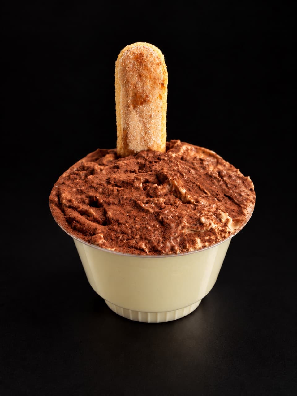 Tiramisu topped with cocoa and a ladyfinger biscuit